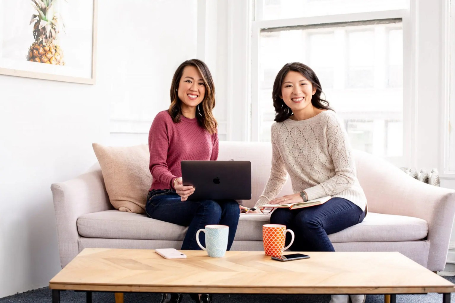 Two women smiling on a couch