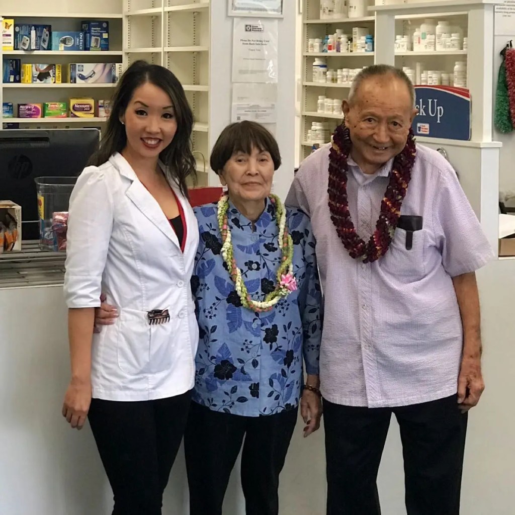 Three people in a pharmacy smiling