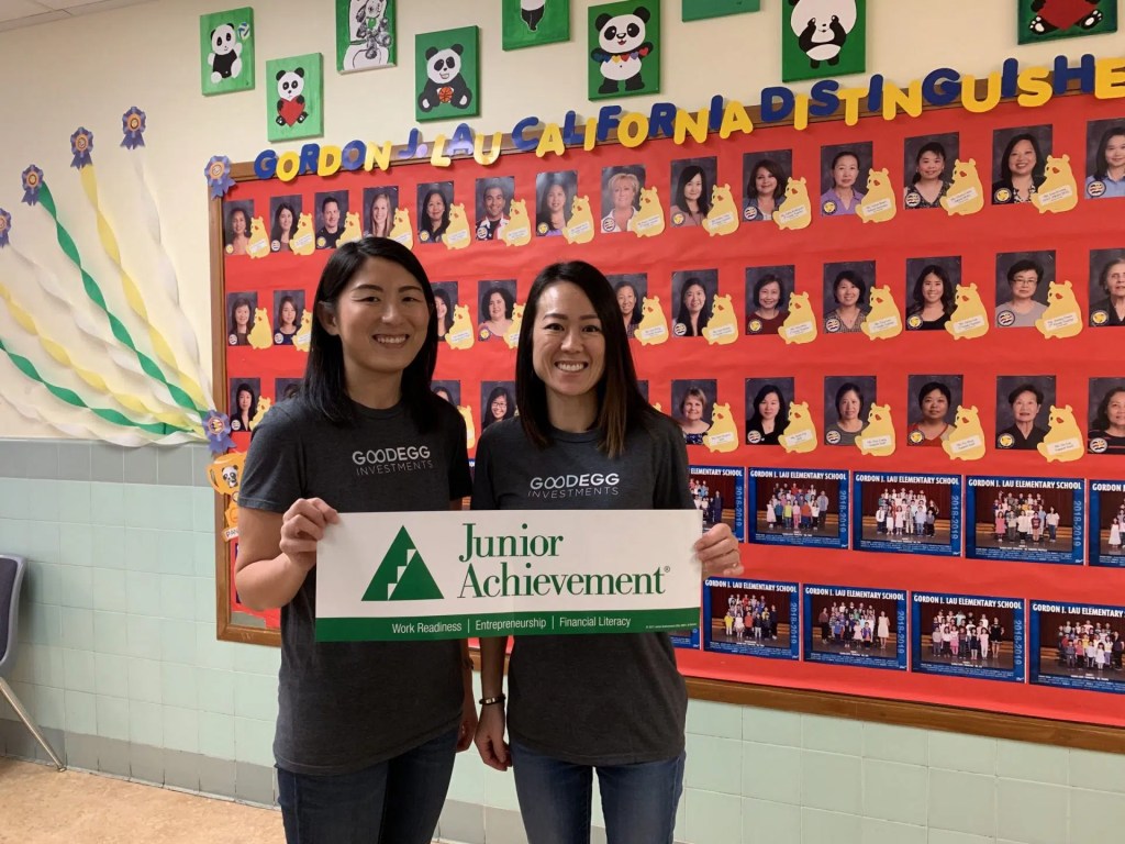 Two women with a Junior Achievement sign