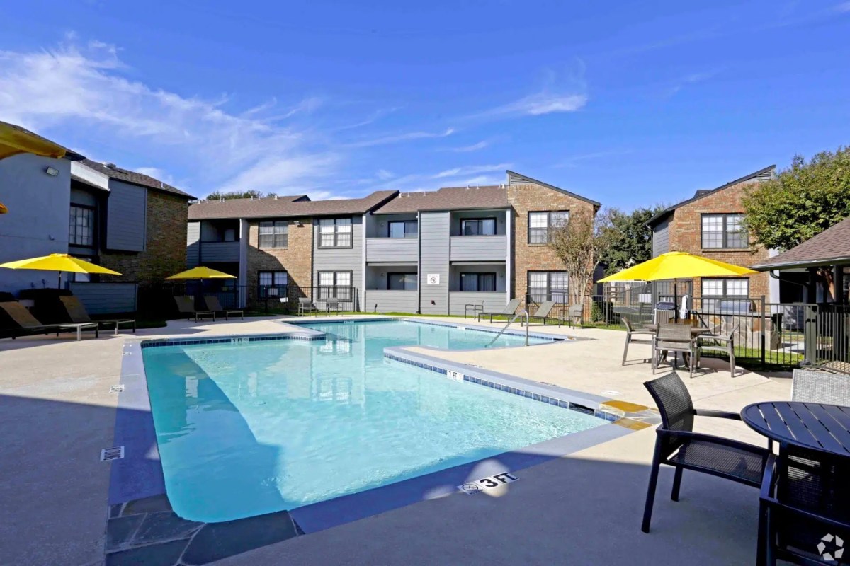 Double swimming area with yellow umbrellas and gray apartments